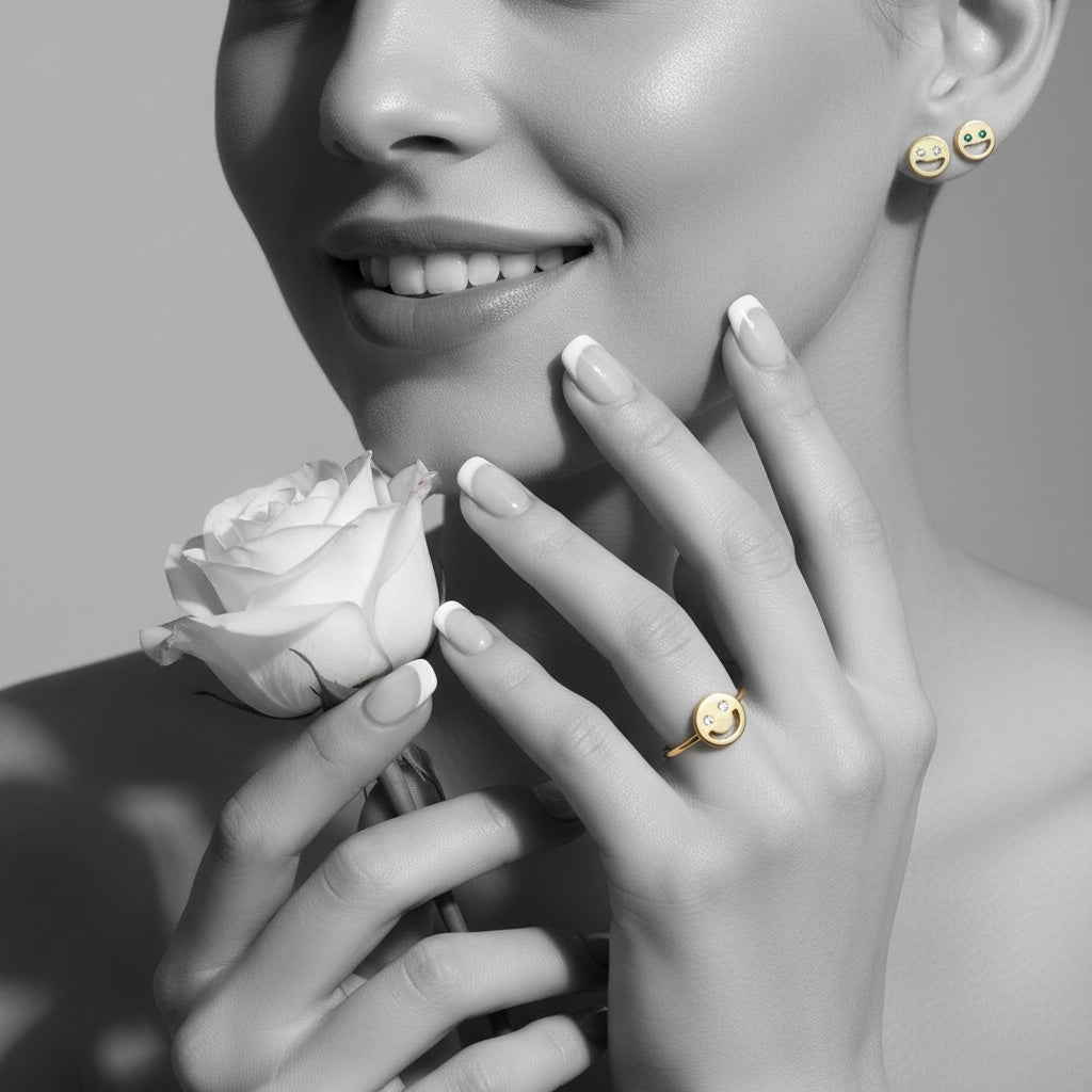 Woman holding a white rose with beans collection gold jewelry on a gray background