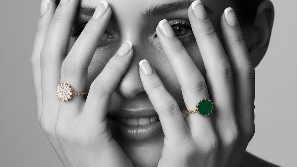 Close-up of a person wearing gold rings with gemstones on a gray background