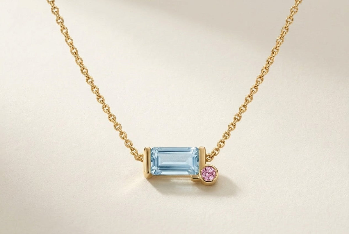 D by DONYDO Tessere Necklace with pink sapphire step – emerald-cut aquamarine in a half bezel with a 2 mm pink sapphire on a fine side-attached yellow gold chain | DONYDO Jewelry